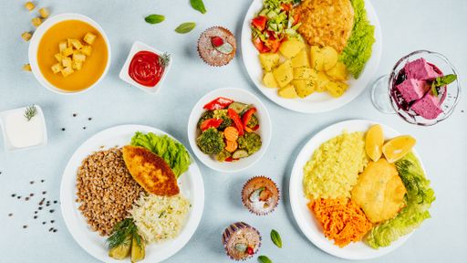 A top view of dinner table with various types of food, boiled potatoes, buckwheat, porridge and salads