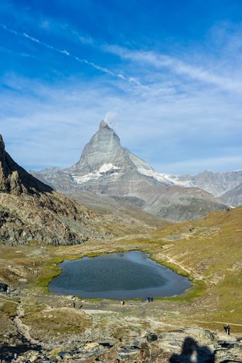 A rocky outcropping overlooking a vast expanse of calm blue water
