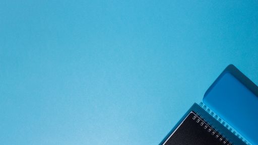 A top view of a smartphone and a notepad on a blue background