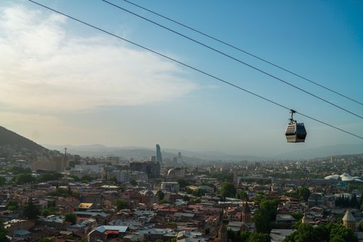 A beautiful shot of a cable car over buildings against blue sky