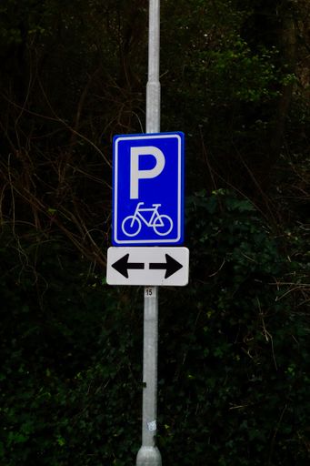 An empty blue parking sign with arrows pointing to both sides