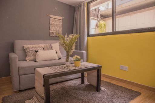 An interior design of a modern room with a sofa next to bedroom