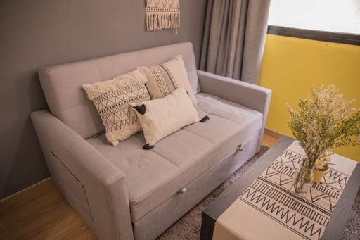 An interior design of a modern room with a sofa next to bedroom