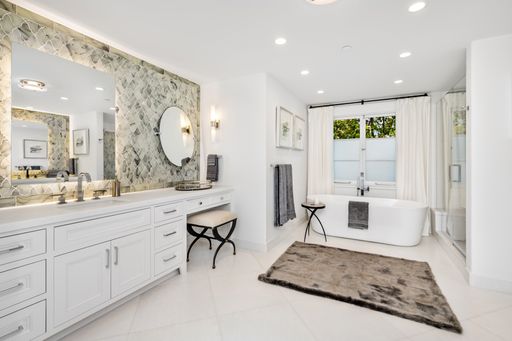 A contemporary bathroom interior featuring two modern washbasins and a pair of inviting bathtubs