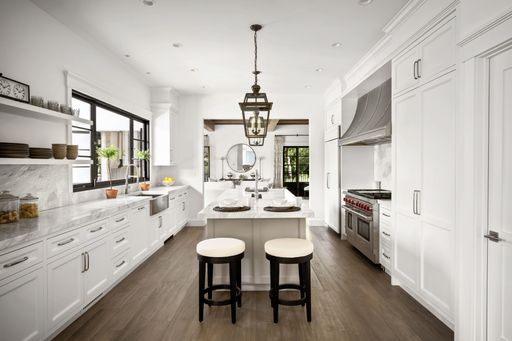 A modern kitchen with an island countertop featuring barstools and a sleek design