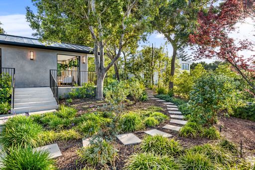 An outdoor scene featuring a backyard with lush green grass and trees in the background