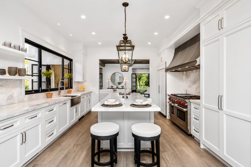 A contemporary kitchen featuring white cabinetry, a sleek center island, and modern appliandces