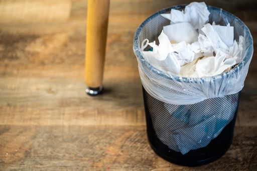A closeup of a trash bin full of tissue papers used for makeup