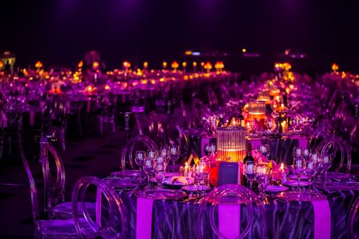 A closeup shot of tables with Christmas decors, candles, and lamps for a large party