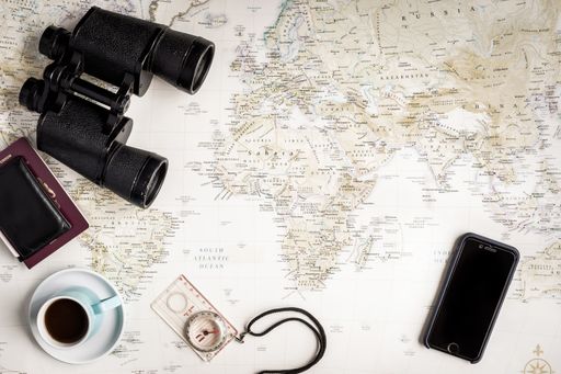 A flat lay of a vintage map for planning a trip or vacation with scattered items