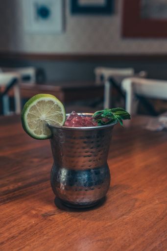 A vertical shot of a strawberry mojito with lemon on the table