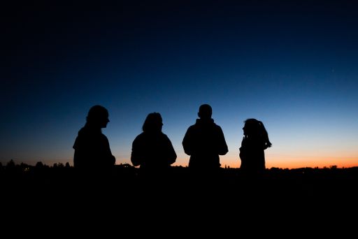 silhouettes in front of blue and orange sky in the evening after sunset