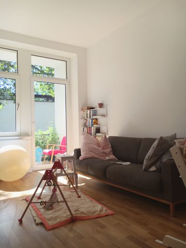 A vertical shot of the sofa, table, and pillows in a room