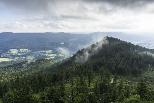 A beautiful landscape of forested mountains under the cloudy sky