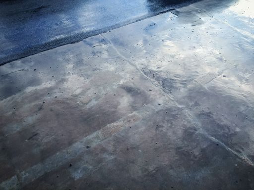 A high angle shot of a wet concrete ground on a rainy day