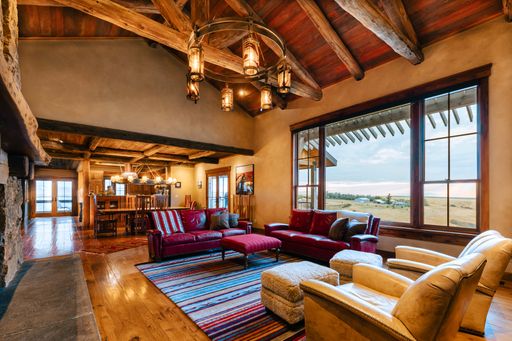 An interior living room with a selection of comfortable furniture and a fireplace along one of the walls