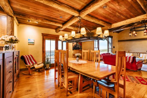 An open and airy dining room featuring large windows along the walls and chairs gathered around a table