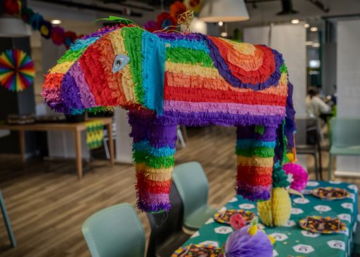 A colorful, traditional Mexican pinata shaped like an animal, resting above a tabletop