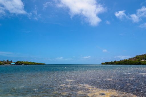 A wide shot of a beautiful view of the ocean with a cloudy blue sky in the background