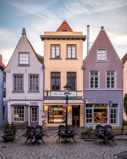 A picturesque cobblestone street in a quaint town lined with brightly colored traditional buildings.