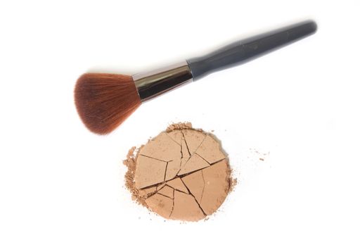 A closeup shot of a bronzer or a contour powder with a brush on a white background