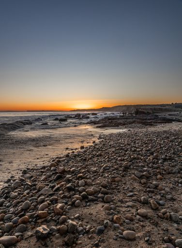 A stunning sunset over the rocky beach and serene ocean. Martha's Vineyard, Massachusetts