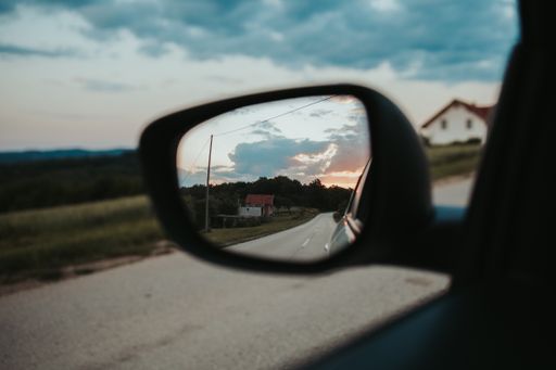The sunset visible from a car mirror
