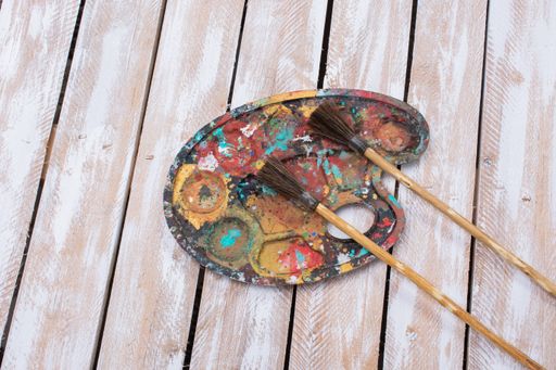 A painting palette and two brushes on a wooden surfac