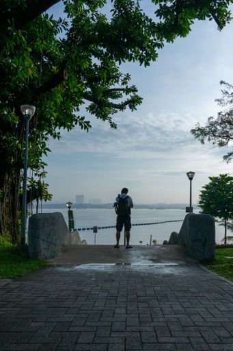 Back view shot of a photographer looking to the sea, Sembawang Park, Singapore