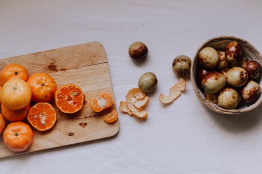 A top view shot of a white table full of tangerines and other fruits