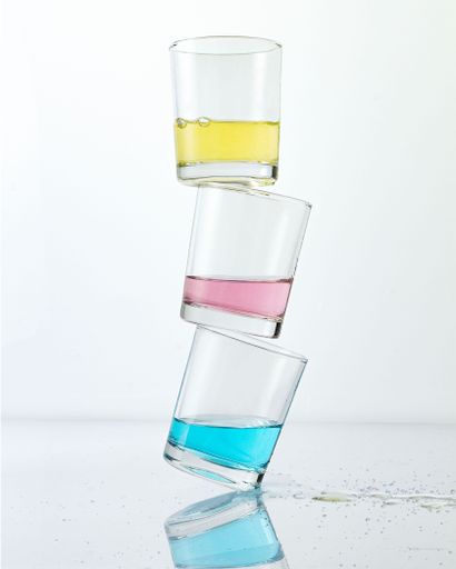 A stack of colorful cocktail drinks isolated on white background