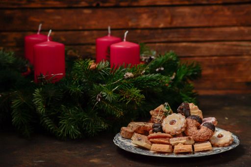 Christmas wreath with red candles made of pine branches with cookies in the Advent season