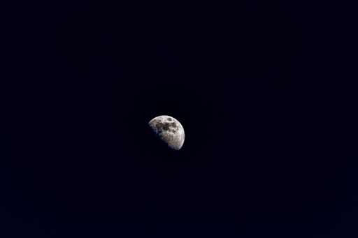 A stunning image of the moon and its reflection in the night sky, seen from the perspective of a space shuttle