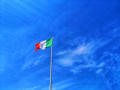 A closeup shot of the flag of Italy on a blue sky background