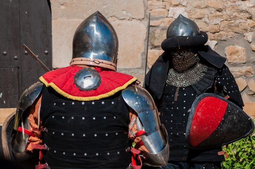 A battle of two medieval warriors fighting with swords and shields in the sunlight