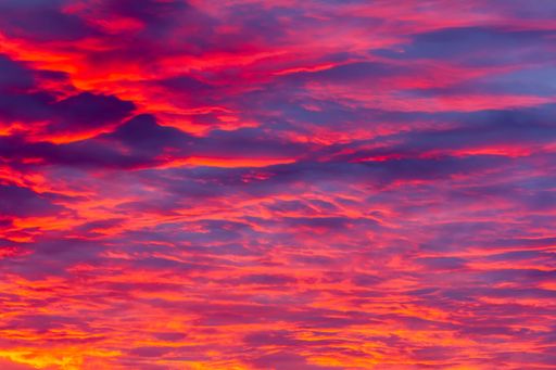 A gorgeous sky during a magical sunset with reddish-pink highlights on gentle purple clouds