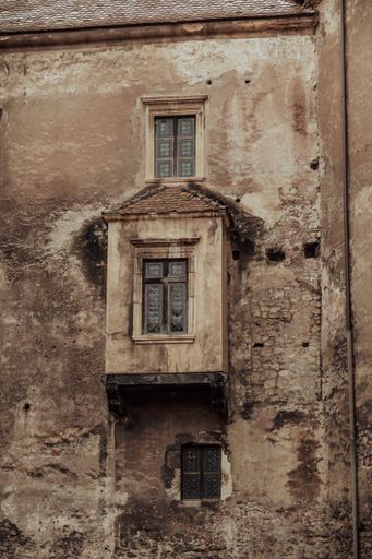 A vertical closeup shot of a damaged stone wall on the Corvin Castle in Romania