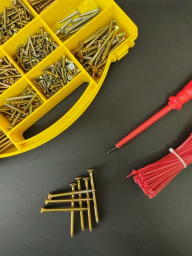An overhead shot of screws and fastening tool kit on a gray background