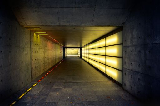 A long, dark tunnel with yellow lights on both sides.