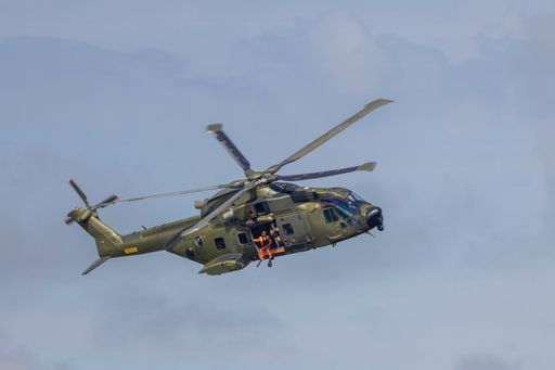 A military helicopter soaring through cloudy skies
