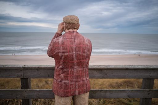 rear view of a person statue pretending to look over the ocean