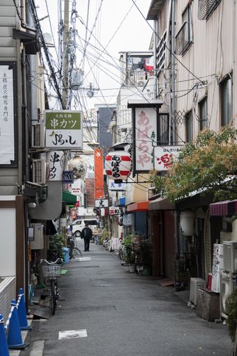 Osaka, Japan- 28 Nov, 2019: People walking on the quiet street in Namba area during morning. Namba is the southern part of Osaka.