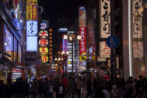 Osaka, Japan- 01 Dec, 2019: Tourists walking around pedestrian walking street at Dotonbori arcade under night light signs in Osaka, Japan