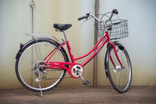 Osaka, Japan- 28 Nov, 2019: A red bicycle is parked against the wall  in Osaka, Japan