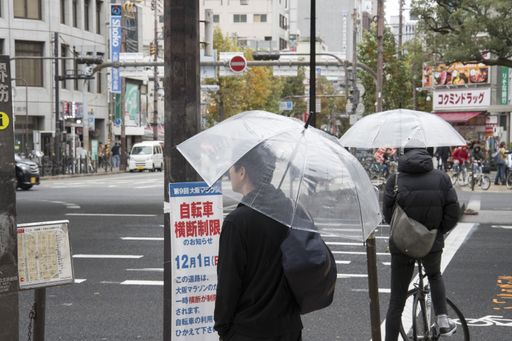 Osaka, Japan- 28 Nov, 2019: People with umbrellas on the wet street in rain day in Osaka, Japan.