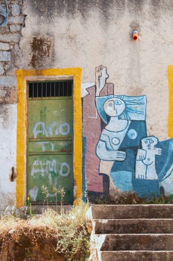 A vertical shot of an abstract creative mural of the family on the wall in Orgosolo, Italy