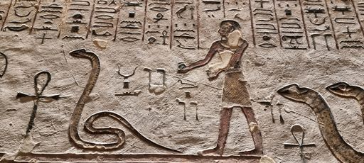 A wall drawing of an Egyptian man with snakes and animals
