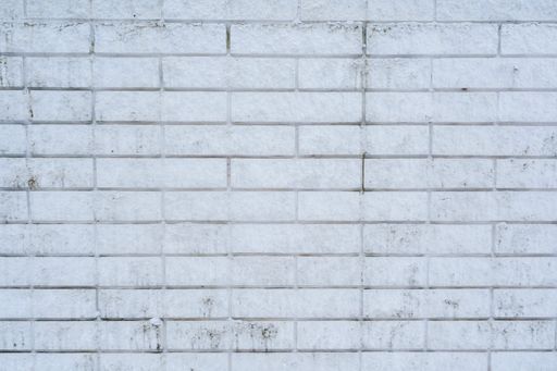 A close-up of a textured white brick wall