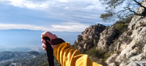 A hiker holding a trekking pole against the background of mountains