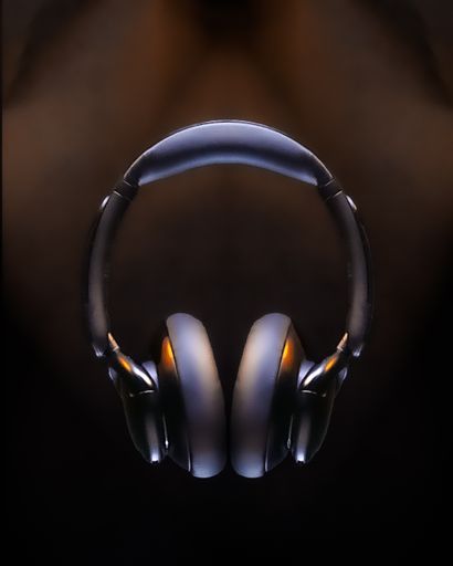 A vertical shot of a wireless headphone on a blurry dark background